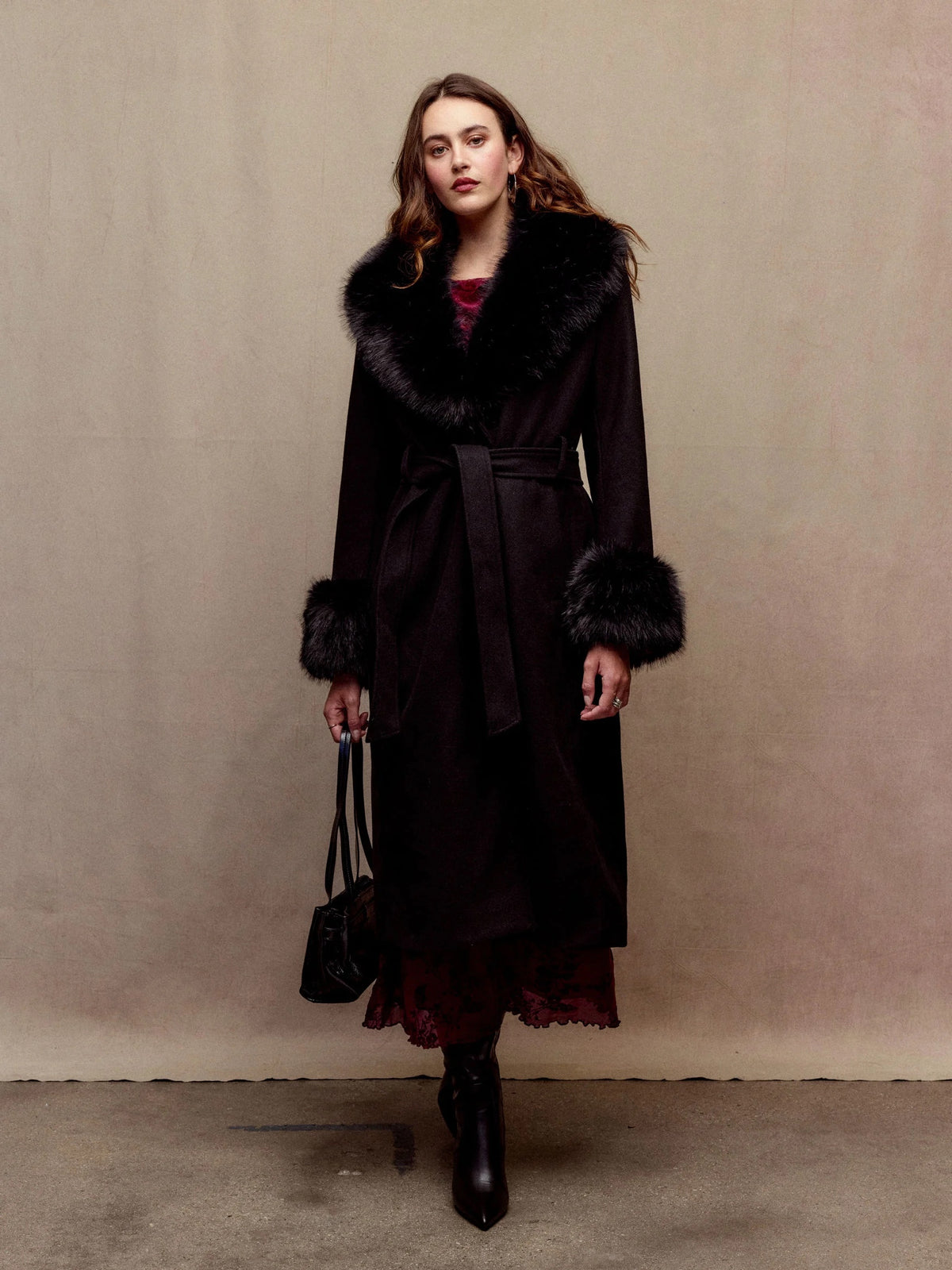 Anastasie black long coat in motion with faux-fur collar