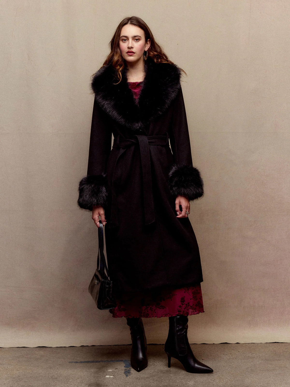 Anastasie black faux-fur collar coat worn with boots, front view